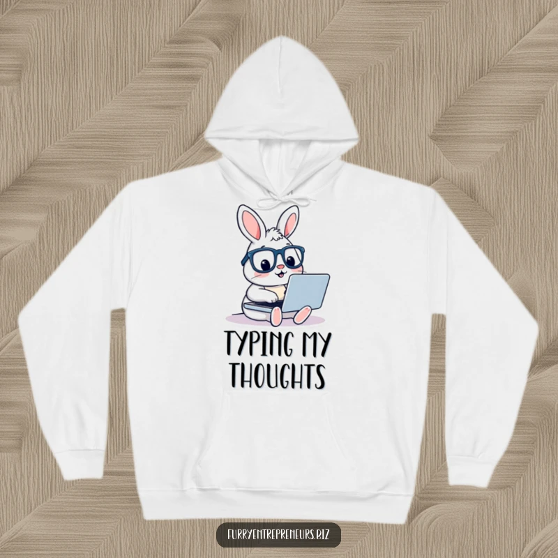 A humorous depiction of a rabbit wearing glasses, diligently typing on a laptop, offering comfortable and funny tech-themed attire on a hoodie.